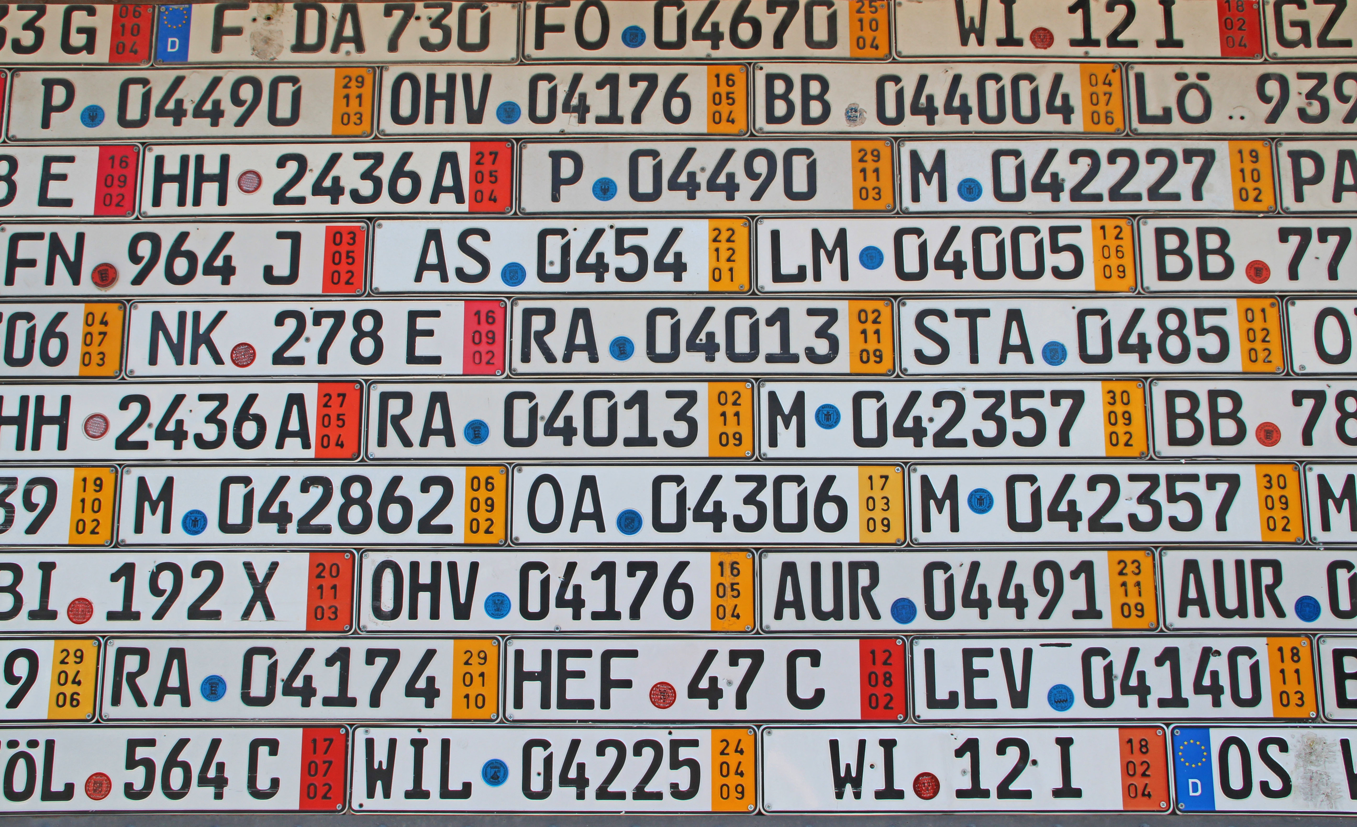 Zbiór tablic rejestracyjnych samochodowych w różnych kolorach i wzorach.